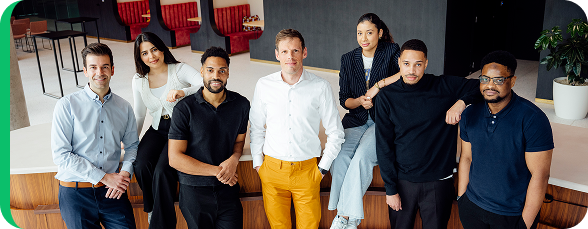 Divers team van energie-experts dat samen poseert in een moderne werkomgeving, als vertegenwoordiging van de klantendienst.