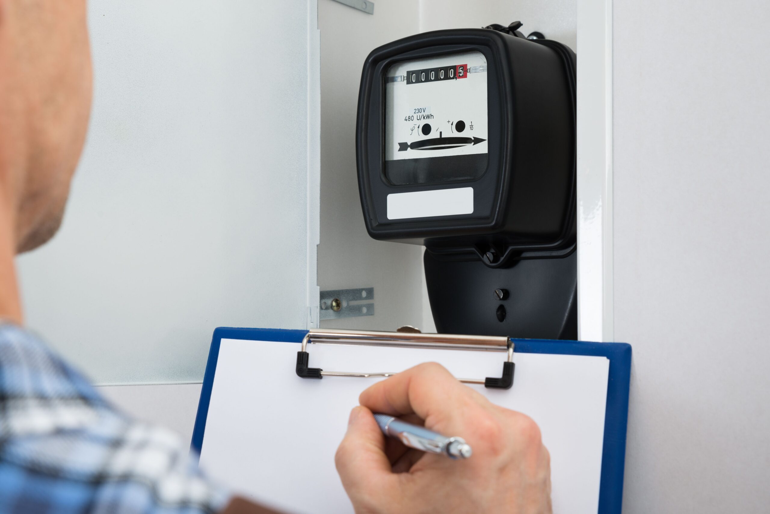 Een DNB technicus neemt de stand van de elektriciteitsmeter op -Energie-vergelijker
